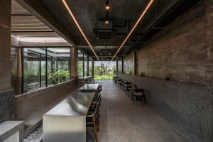 A modern dining area with a large silver table surrounded by chairs, well-lit and inviting