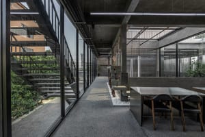 Bright and inviting office space with grey walls, a large window, and a dining table, featuring two chairs and natural light
