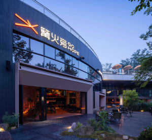 Modern Asian restaurant with a large dining area, wood and metal elements, umbrellas, and a comfortable atmosphere