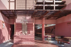 Cozy modern restaurant with pink walls, a large window, and chairs around a dining table