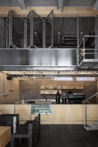 A modern kitchen with wooden walls and floors, featuring a refrigerator, microwave, and sink, with a well-planned layout for cooking and food preparation