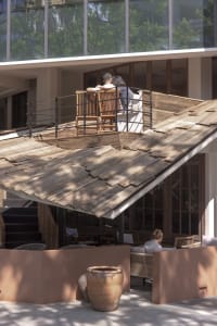 An outdoor living area with a wooden deck, comfortable seating, and a dining table, set in a relaxed and inviting atmosphere