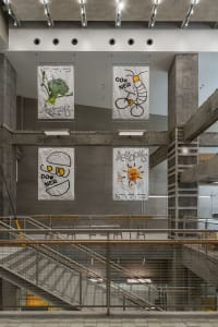 A bright and inviting open space with white posters on the walls, featuring three chairs in different locations