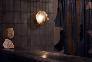A modern bathroom with two sinks, a shower curtain, and a towel rack, featuring a tiled design on the walls