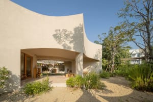 A modern house with a curved wall and large window, featuring clean lines and minimalistic elements, with ample natural light and a bright atmosphere