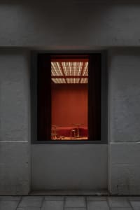 A warm and inviting dining area with orange walls, a dining table, and two chairs, creating a cozy atmosphere