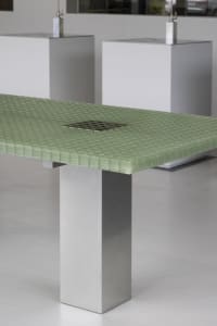 A modern cafe scene with a green metal tabletop and white minimalist walls