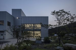 A modern office building with a concrete and glass facade, featuring a well-organized interior with ample space for employees