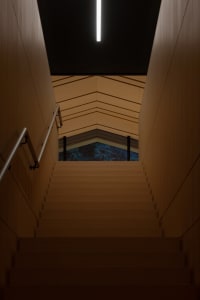 A real photo of a well-lit wooden staircase in a building, with a sense of depth and dimension