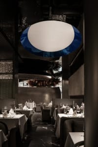 Empty restaurant with wooden tables, chairs, and wine glasses, creating an inviting atmosphere for dining