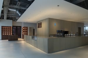 Open and inviting cafe interior with a large wooden counter, sink, and various beverage options