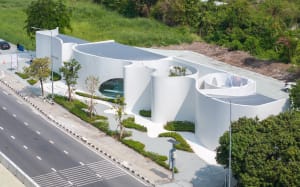 Modern building with a large white living room surrounded by smaller rooms, featuring clean lines and minimalistic elements
