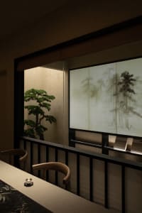 Dining area with a wooden theme, featuring a table and chairs, a potted plant, and a cozy atmosphere