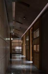 A traditional hallway with wooden doors, lights above, and a classic design
