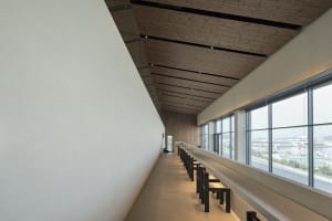 Empty restaurant with wooden walls and ceiling, featuring tables and chairs in a comfortable dining area with an inviting atmosphere