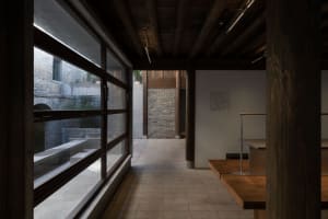 Modern restaurant interior with wooden floors and walls, large windows, and natural light