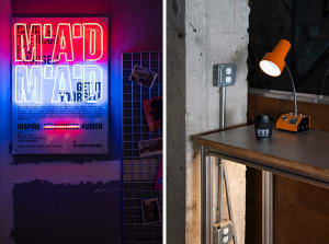 Modern room with a concrete wall, a table, and a cup, featuring a neon advertisement with a "had it" sign