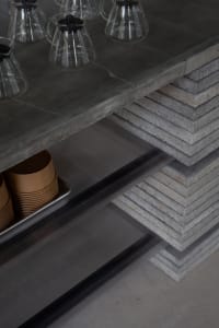 Industrial kitchen area with a countertop featuring cups and bowls, suggesting a functional workspace for food preparation and serving
