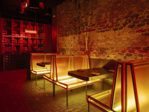 A warm and inviting restaurant interior with yellow chairs and metal tables, soft diffused lighting, and a cheerful atmosphere