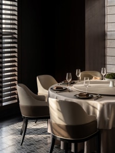Elegant dining space with a round table, four chairs, and fine dinnerware, set for a formal gathering