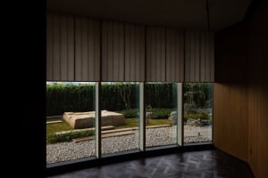 A well-lit room with two benches, one near a large window and the other further back, creating a comfortable atmosphere