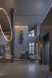 Open modern living space with natural light, staircases, a countertop, sink, and potted plants