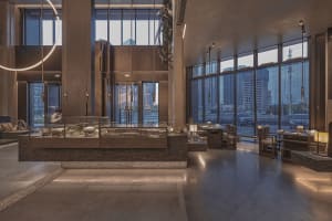 A restaurant interior with a large window, chairs, a dining table, and couches, creating an inviting atmosphere with ample seating