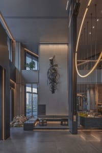 A spacious office space with elegant furniture, potted plants, and ample seating options, well-lit for a welcoming ambiance