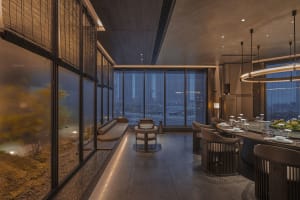 A modern restaurant interior with natural light, chairs, and a dining table, creating a comfortable and inviting atmosphere