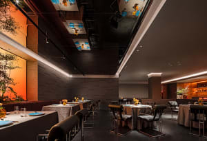 Elegant dining space with wooden furniture, multiple tables, and wine glasses, set in a sophisticated atmosphere