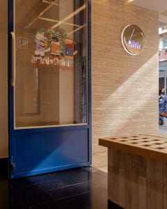 A cozy coffee shop interior with natural light, two benches, and a clock on the wall