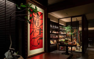 A bustling Asian restaurant with a red Chinese character painting on the wall, surrounded by bowls and bottles, suggesting a variety of traditional dishes and ingredients