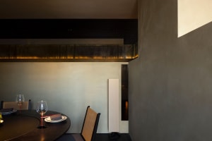 Empty dining area with a wooden table and chairs, a wine glass, and an inviting atmosphere