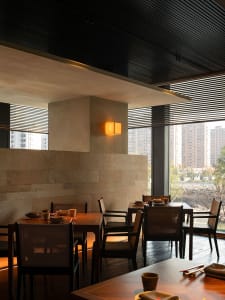 An empty restaurant with wooden tables and chairs, dimly lit for a cozy ambiance