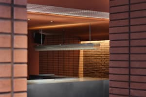 A brick-walled commercial space with a metal lamp and warm ambiance, suitable for events or food service