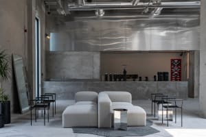 Open living area with a large couch, two chairs, and white walls, giving it a clean and minimalist look