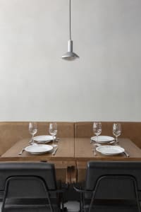 Elegant dining area with brown leather chairs, multiple tables set with wine glasses, plates, and cutlery, creating a sophisticated ambiance
