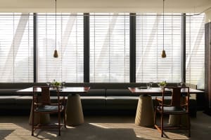 Bright modern restaurant interior with natural light, dining tables, and chairs