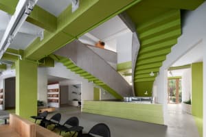 Modern interior space with a green staircase, a countertop, and sleek design elements