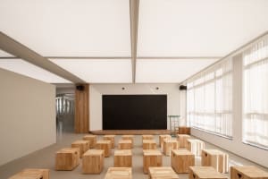 An empty classroom with a blackboard and wooden chairs arranged in rows, creating a sense of organization and calm atmosphere