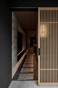 Dimly lit hallway with wooden walls and floors, featuring two doors and a warm atmosphere