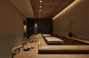 Empty restaurant kitchen with wooden tables and chairs, sinks, and a focus on practicality and organization