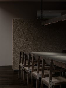 A warm and inviting dining area with a large wooden table surrounded by chairs, creating a welcoming space for guests to gather and enjoy meals together