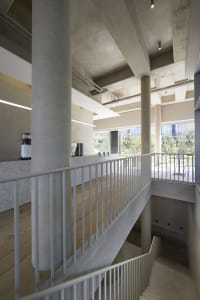 Open modern space with metal railings on two sets of stairs, clean lines, and simple design elements, well lit by natural light