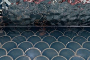 Aqua-colored tile floor with a unique pattern in a bathroom, creating a calm and relaxing atmosphere with a soothing blue color scheme