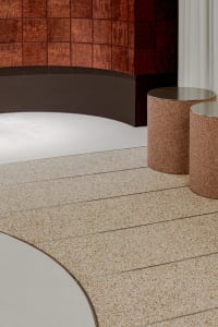 Two round marble tables in a modern hallway with sophisticated lighting creating a warm and inviting atmosphere
