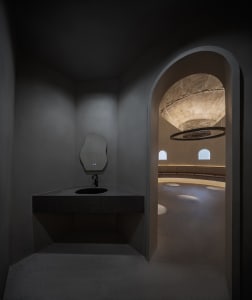 A modern bathroom with two sinks, a large mirror above one sink, a smaller mirror on the right, and a toilet near the right wall