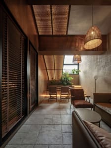 Open living area with a large window, two chairs, and a couch, featuring modern design and natural light