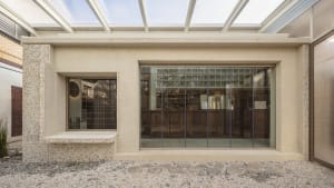 A modern building with large windows, glass panels, and a concrete exterior, designed to provide ample natural light and open spaces