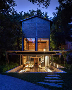 Modern house with a brick exterior, open living area, and patio with comfortable seating arrangement